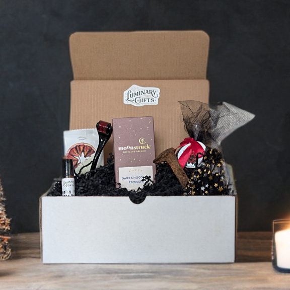 HEX YA LATER Box contains a rustry Railroad Stake, 3 apache tears in a black and gold bag,Moonstruck Dark Chocolate Espresso Bar, a Cherry Rose Bath Bomb,
a Micro-needle Roller.Blood Orange Crisps and a Spicy AF Ginger Roller