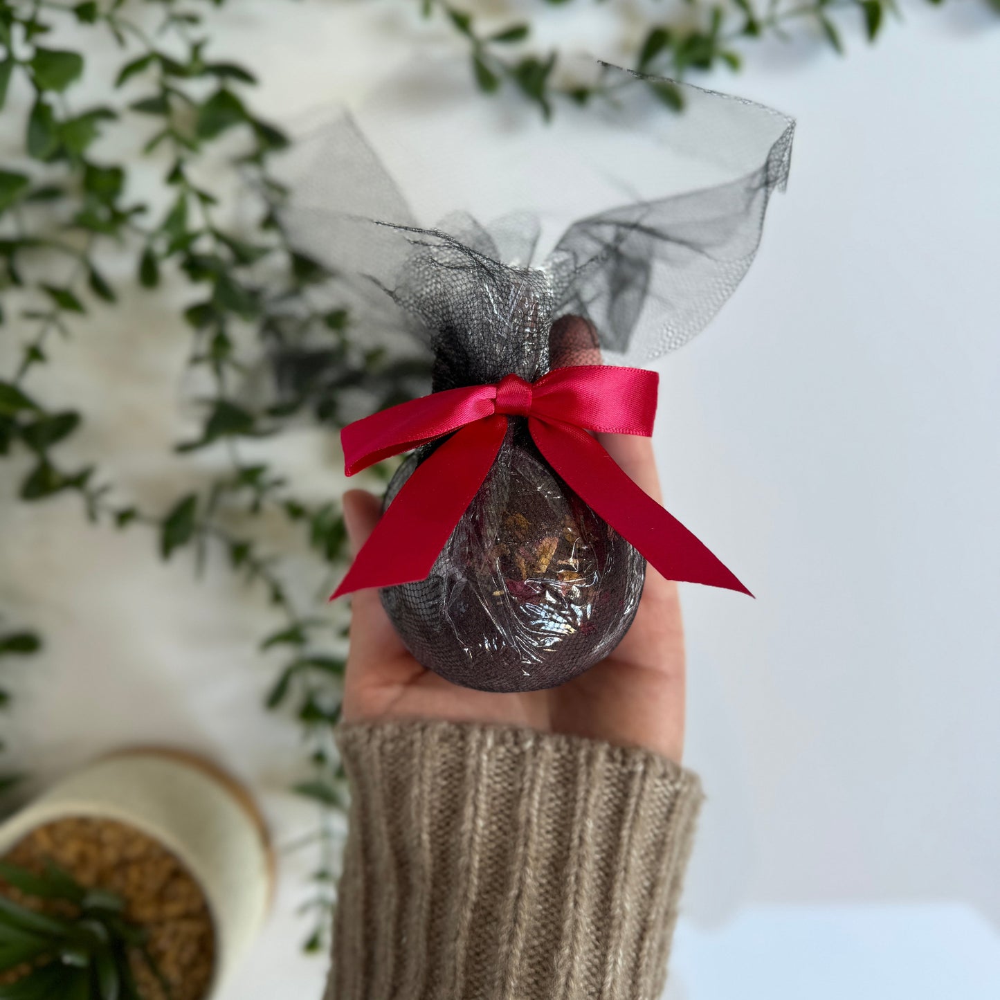 black cherry bath bomb in black wrapping with a red ripping