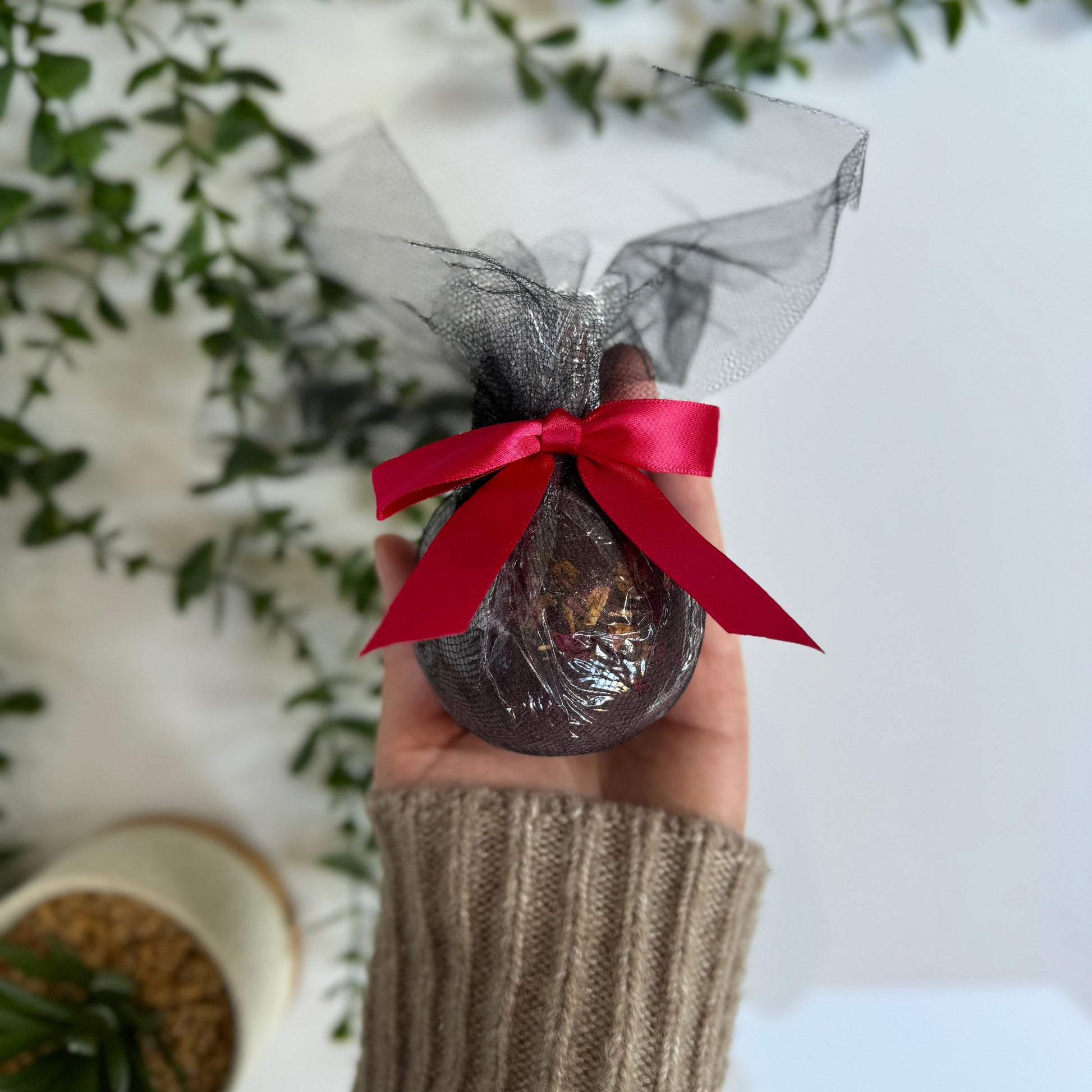 black cherry bath bomb in black wrapping with a red ripping